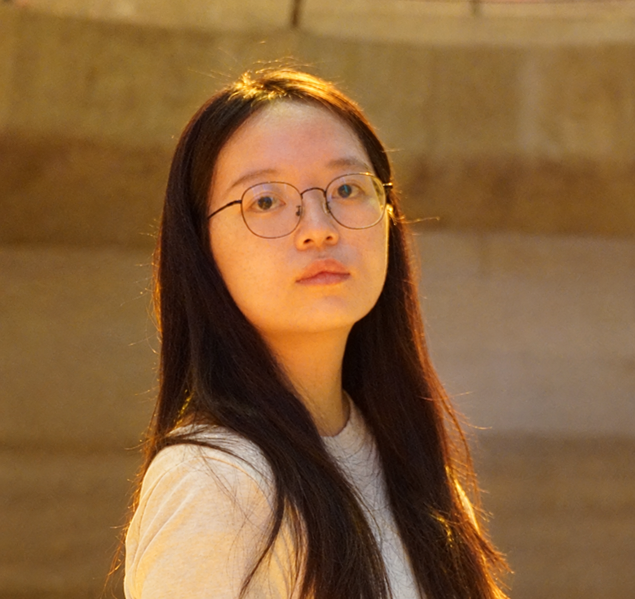an Asian female with glasses, long hair, and an off-white T-shirt